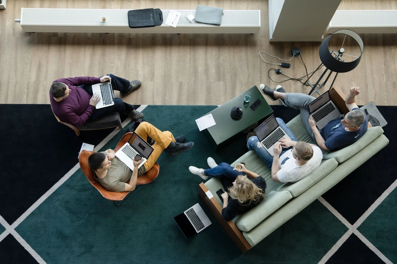 Five people working together with laptops